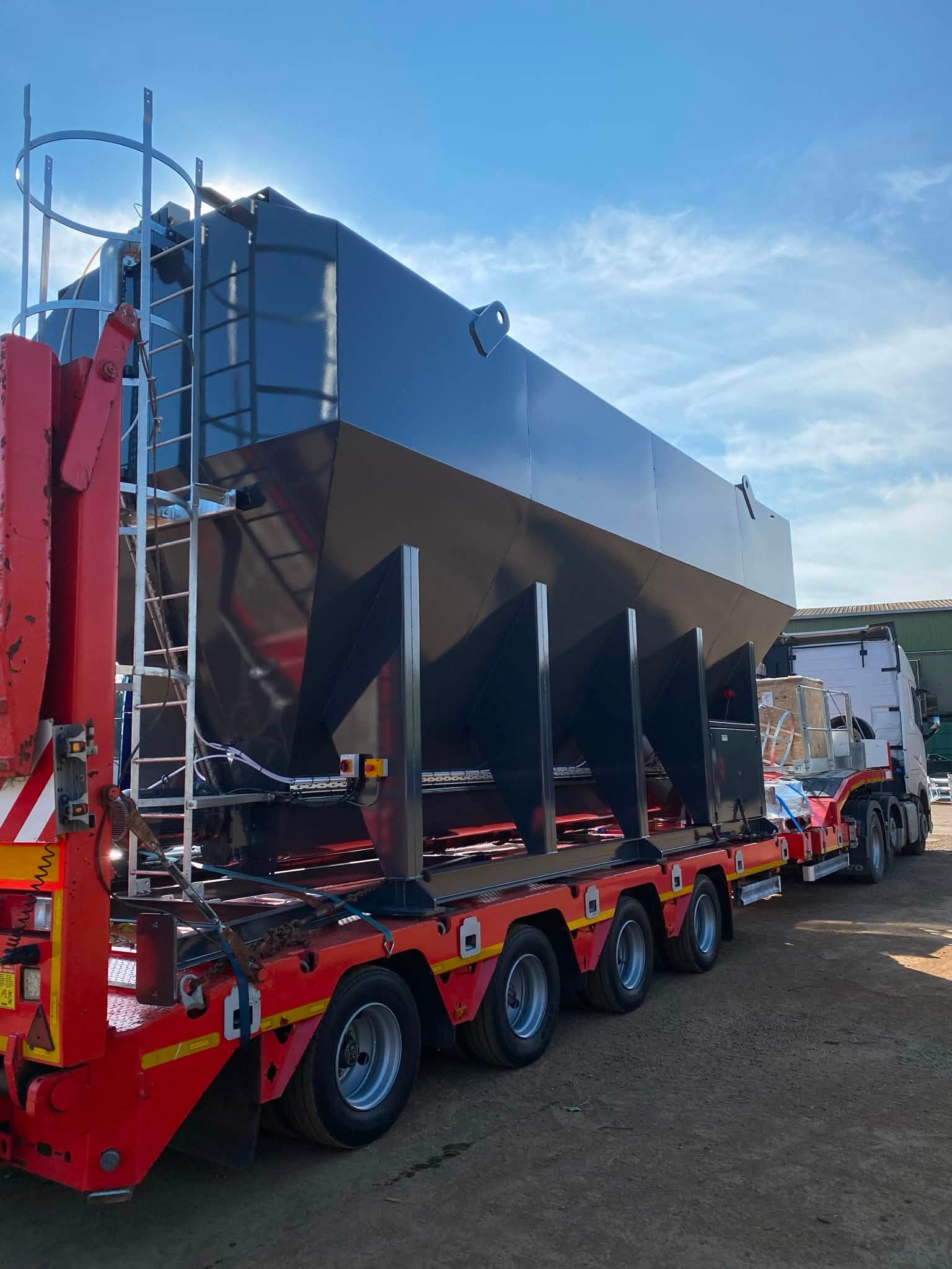 Side view of a new 48m³ low-level silo on a transport trailer